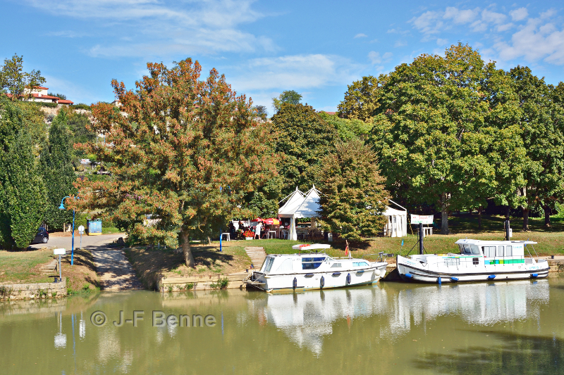 Le port de Valence sur Baïse par une belle journée de septembre. Quelques aménagements touristiques et deux bateaux blancs amarrés.